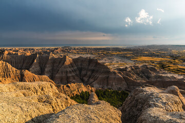 Landscape sweeping view of the hills or hoodoos of the Badlands in golden light.