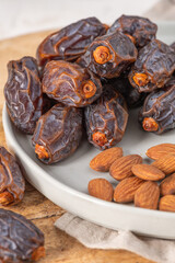 Medjool dates and almonds on a plate, showcasing a healthy snack option with rich textures and natural colors, perfect for nutritious eating and culinary inspiration
