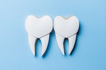 A close-up image of a pair of white teeth against a bright blue background