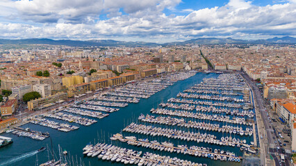 Aerial view of Marseille, France, showcasing the Old Port filled with yachts, surrounded by...