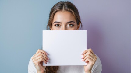 young woman holding blank paper in front of her face against a gradient lavender blue background
