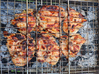 Juicy, grilled chicken breasts sizzle on a barbecue grill, perfectly charred and ready to be enjoyed. A feast for outdoor gatherings!