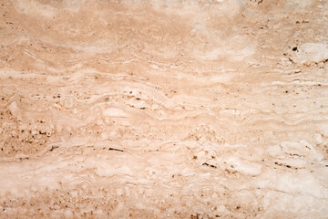 A close-up view of a smooth, beige marble surface showcasing subtle waves and textures, perfect for enhancing interior design aesthetics.