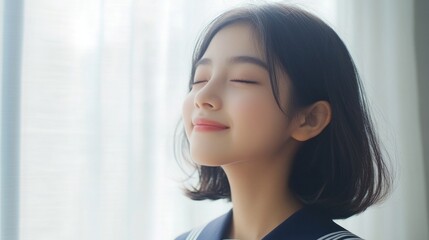Fototapeta premium Portrait of a serene Thai teenager with short dark hair in a Japanese student uniform smiling blissfully by a bright window with soft natural light.