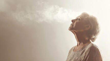 Calm elderly woman experiencing serenity and mindfulness while exhaling deeply against a soft background showcasing tranquility and reflection.