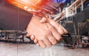 Mechanized industry concept, business handshake in factory.