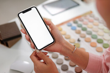 Phone mockup screen in interior designer's hand who is looking for design information