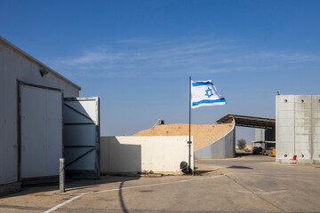 The flag of Israel at a construction quarry with hangars.