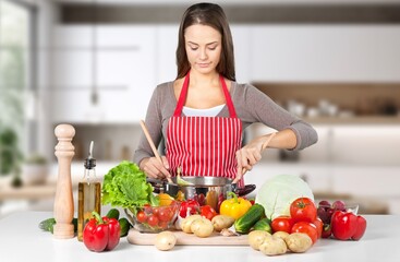 Shot of beautiful young woman cooking food in kitchen