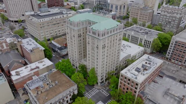 A beautiful overhead view from a drone UAS of a large hotel building in a large urban city  with office buildings, fancy upscale picturesque hotels. Overhead tilting shot from aerial drone UAS.