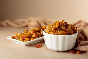 Yellow sultana raisins in a white bowl.