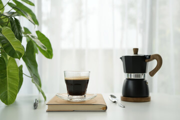 coffee cup and black moka pot by the window, minimal home