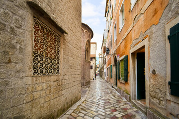 Fototapeta premium A narrow alley alongside the Cathedral of Saint Tryphon in the medieval old town of Kotor, Montenegro.