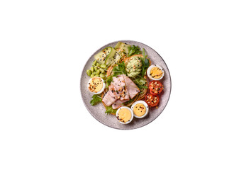 Healthy breakfast consisting of boiled eggs, slices of ham, tomatoes, green beans, aioli sauce