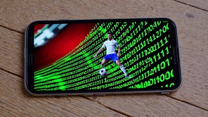 Soccer player kicking a ball is displayed on a smartphone screen, with binary code forming a dynamic backdrop, suggesting online sports betting, virtual reality, or sports technology - Powered by Adobe