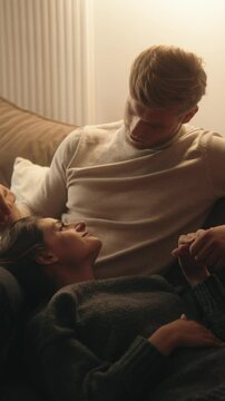 Couple spends quality time together at home, sharing an intimate moment on the couch.
