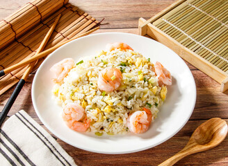 Shrimp Fried Rice with Egg served in plate with chopsticks and spoon isolated on wooden table side view of taiwan food