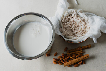 Preparing almond milk with cinnamon using cloth strainer