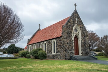 A traditional stone church with a bright red roof on a cloudy day