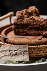 piece of chocolate cake with cream, kraft paper with the inscription 