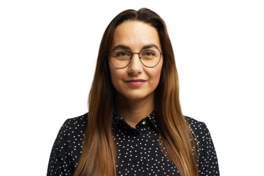 Woman with long hair and glasses wearing a black polka dot shirt poses for a professional portrait
