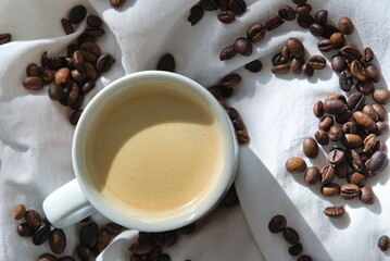 Aromatischer Kaffee in Kaffeetasse umgeben von -Bohnen