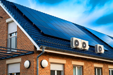 An air-source heat pump unit is situated outdoors in a contemporary Dutch home equipped with solar panels.