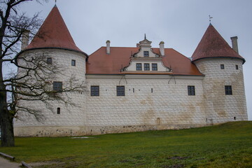 Bauska Castle in Latvia, with its medieval towers and red tiled roof.