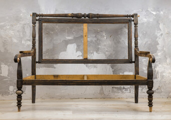 Frame of an old or antique chair or sofa, with upholstery missing.