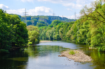 Obraz premium Tranquil River Landscape Surrounded by Lush Greenery