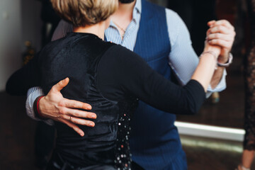 Couples dancing traditional latin argentinian dance milonga in the ballroom, tango salsa bachata kizomba lesson in red and purple lights, performance rehearsal, evening dance school class festival