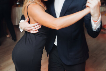 Couples dancing traditional latin argentinian dance milonga in the ballroom, tango salsa bachata kizomba lesson in red and purple lights, performance rehearsal, evening dance school class festival