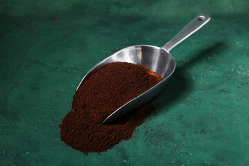 Scoop of coffee powder on green grunge background