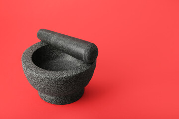 Mortar and pestle on red background