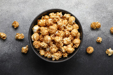 Bowl with tasty popcorn on grey background