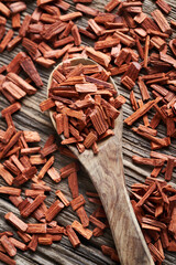 Pieces of red sandalwood on a wooden spoon, top view