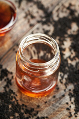 Black cumin or Nigella sativa seed oil in a glass jar. Healthy anti-inflammatory and antioxidant supplement.