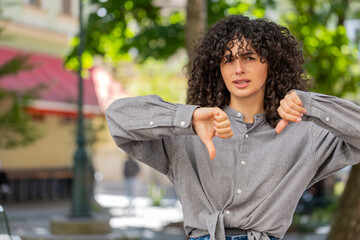 Dislike. Upset Caucasian young woman showing thumbs down sign gesture, expressing discontent...