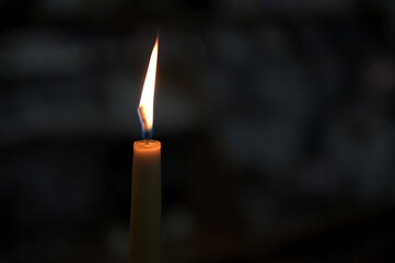 Burning candle on dark background, space for text. Memory day.