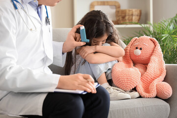 Upset little girl and doctor with inhaler at home
