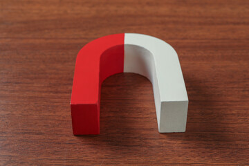 One horseshoe magnet on wooden table, closeup