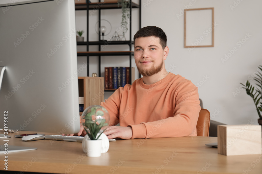 Poster young bearded man using computer at table in office