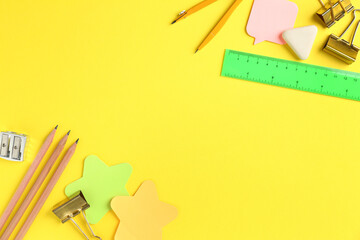 Flat lay composition with ruler and other stationery on yellow background, space for text