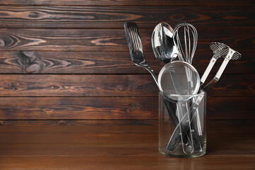 Set of cooking utensils on wooden table, space for text