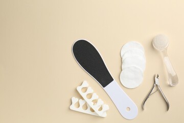 Set of pedicure tools on beige background, flat lay. Space for text
