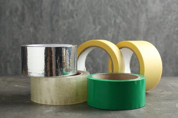 Rolls of different adhesive tapes on grey table