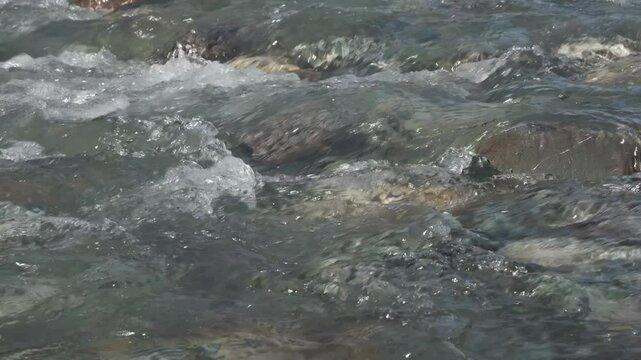 Mountain river running over stones in sunlight 