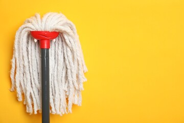 String mop on yellow background. Space for text