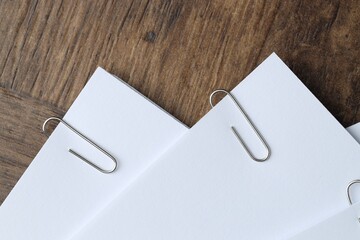 Paper notes with clips on wooden table, top view