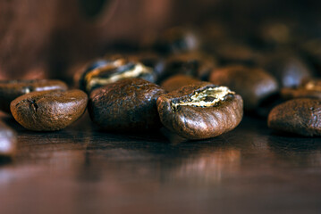 Freshly roasted coffee beans on a metallic surface, close-up view